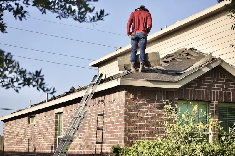 Professional roofer working on a residential roof in Rial Side